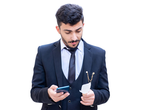 Arabic man wearing suit holding an invoice and checking the sum of the items that he bought from the supermarket - Photo, Image