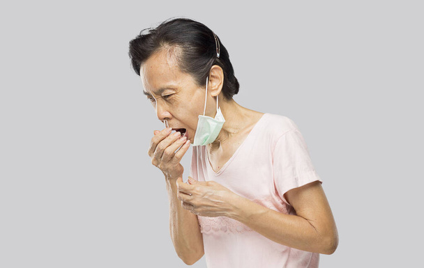 vecchia donna asiatica coperto la bocca a causa di tosse e mal di gola - Foto, immagini