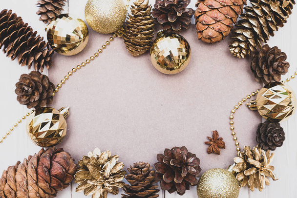 Le cadre est fait de boules de Noël dorées, de cèdre, de pin et de cônes d'épinette. Composition festive dans des couleurs chaudes avec place pour le texte. - Photo, image