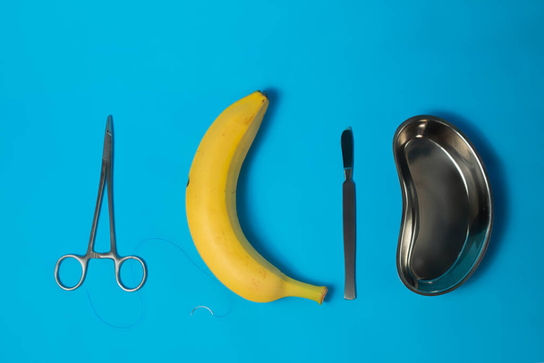 Хірургічні інструменти з медичним кубком і шви на банані.. - Фото, зображення