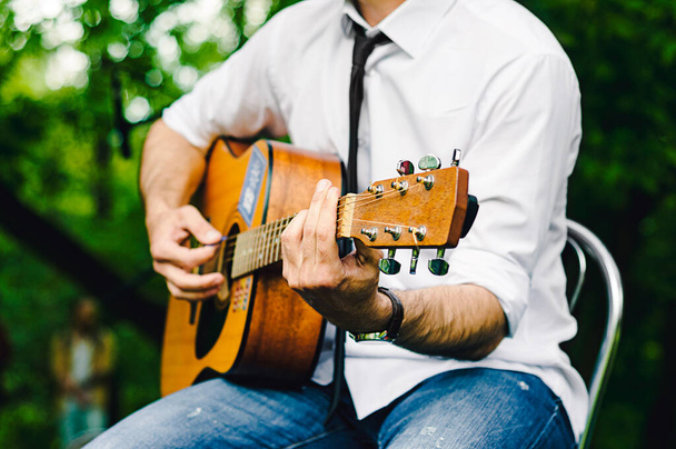 El cantante toca una guitarra acústica y canta en un concierto - Foto, imagen