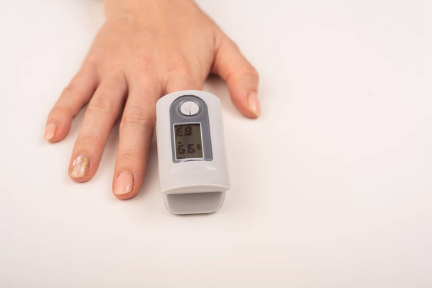Ženská ruka s měřicím zařízením nasycení. Hladina kyslíku v krvi v koronaviru - Fotografie, Obrázek