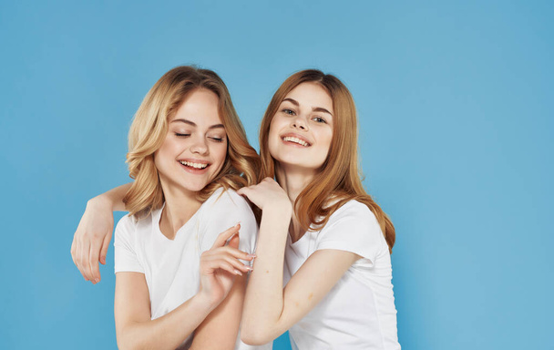 two funny girlfriends in white t-shirts spring hug communication - Foto, immagini