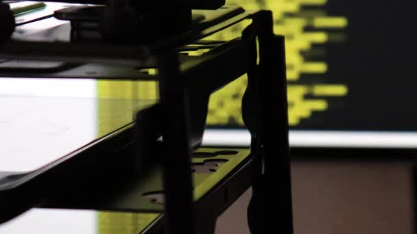 Siyah ekranda hareket eden sarı bilgisayar yazılım kodu cama yansıyor. Raf sunucu tabanı, dinamik metin çalışan ve pc ekranında akan soyut bilgisayar hack 'leme işlemi. - Video, Çekim