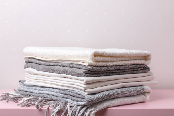 A stack of rolled blankets, sheets, and towels on the table. - Foto, afbeelding