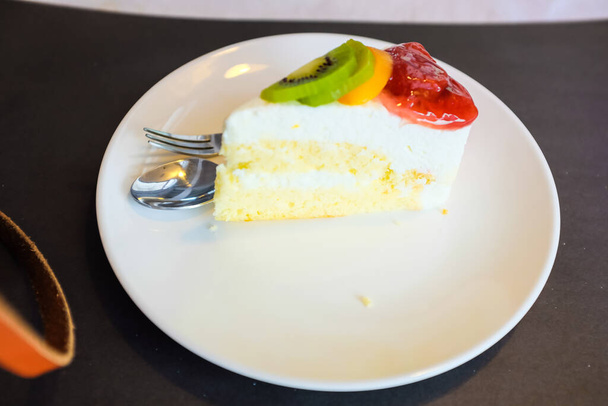 Heerlijke witte romige taart met bessen en kiwi 's op tafel zoete taart - Foto, afbeelding