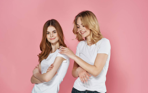 two funny girlfriends in white t-shirts spring hug communication - Foto, imagen