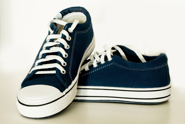 Ένα ζευγάρι μπλε πάνινα παπούτσια σε λευκό φόντο. καλοκαιρινές παντόφλες - Φωτογραφία, εικόνα