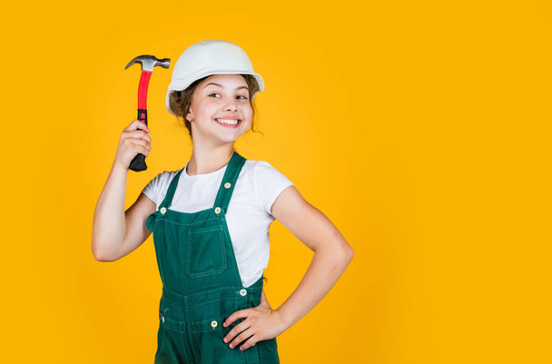 teen girl builder in protective helmet use hammer, protection, copy space - 写真・画像