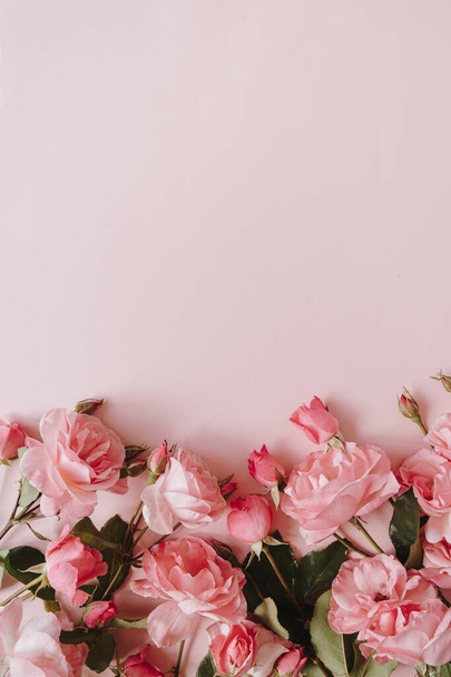 Roze roos bloemen boeket op roze achtergrond. Vlakke lay, bovenaanzicht minimale bloemsamenstelling. - Foto, afbeelding