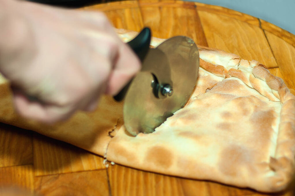 Rebanada de pizza caliente con queso derretido en una mesa de madera rústica. - Foto, imagen