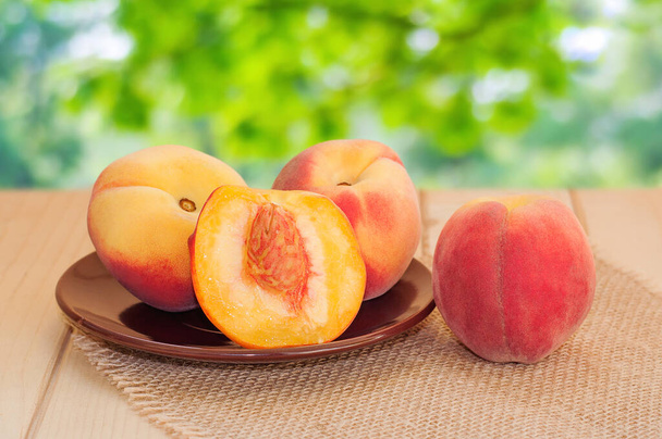 Fresh sweet group of peaches on wooden background in the garden - Photo, Image