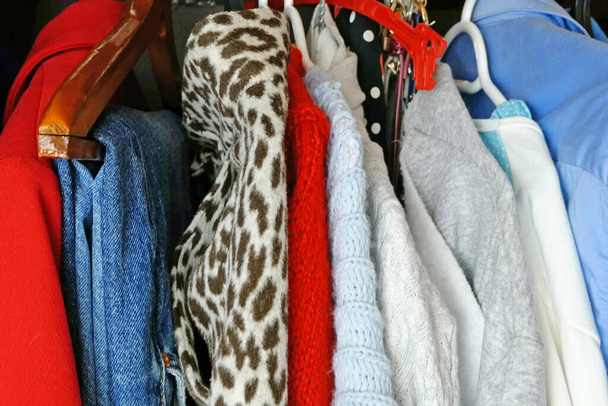 Современная женская одежда, большой гардероб с различной одеждой, домашние вещи, выбор одежды в шкафу, крупный план - Фото, изображение