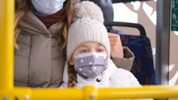 Die COVID-19-Epidemie. Schutz vor Coronavirus im öffentlichen Verkehr in Europa. Kind und Mutter essen in öffentlichen Verkehrsmitteln unter medizinischer Schutzmaske. - Filmmaterial, Video