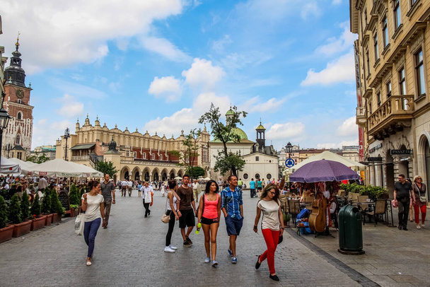 Krakow, Poland - July 29th 2018: Tourists at Grodzka Street at main market square, with the Cloth Hall in the background and cafes in the foreground, old town in Krakow, Poland - Foto, Imagem