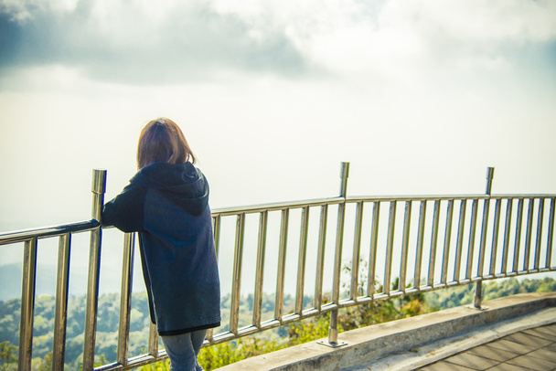 Самотня жінка стоїть біля сталевого паркану і бачить небо1
 - Фото, зображення