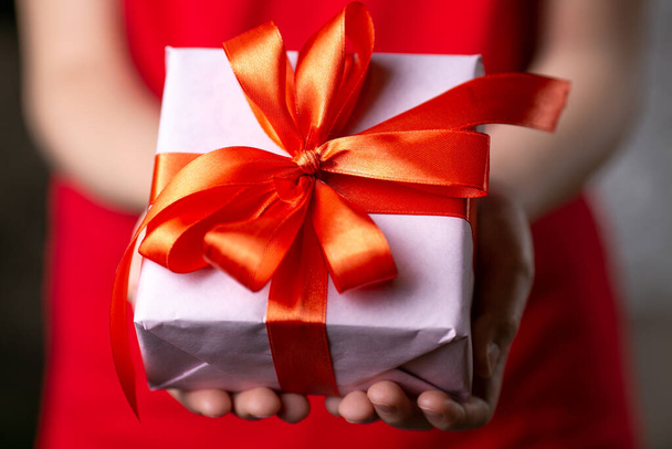Child Hands Holding Gift With Red Ribbon. - Photo, Image