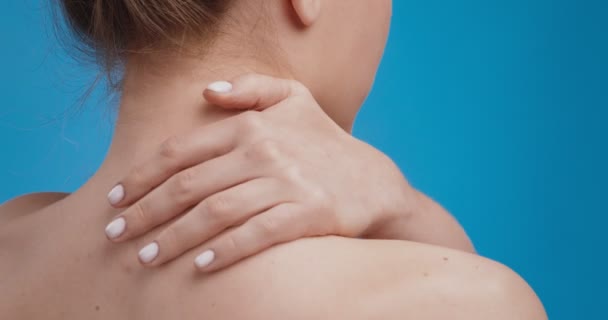 Κοντινό πλάνο της νεαρής γυναίκας να κάνει μασάζ στο λαιμό της, εφαρμογή κρέμας θεραπείας σε πονεμένους μυς, προβολή πλάτης - Πλάνα, βίντεο