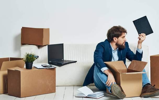 Muž v obleku emoce práci pohybující krabice na podlaze - Fotografie, Obrázek
