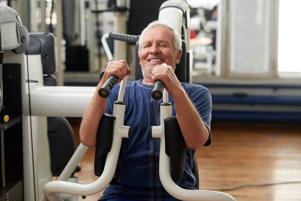 Hombre mayor haciendo ejercicio en el gimnasio. - Foto, Imagen
