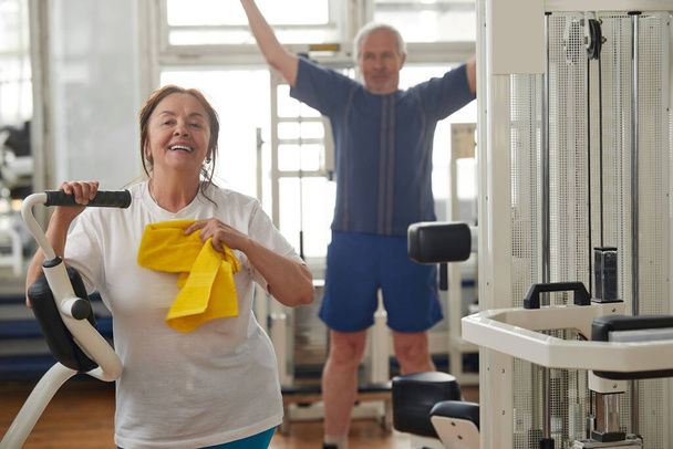 Šťastná starší žena po tvrdém tréninku v tělocvičně. - Fotografie, Obrázek
