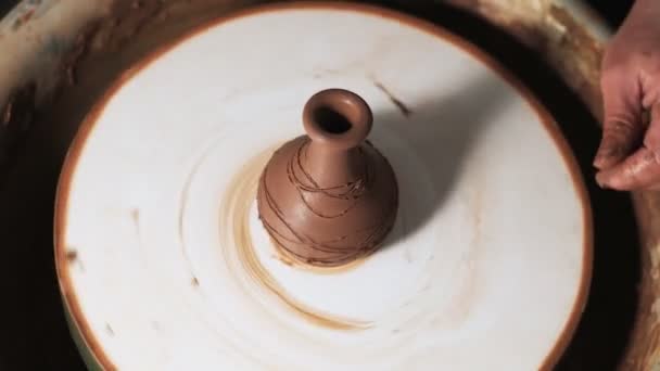mani che lavorano argilla sulla ruota del vasaio. Il vasaio modella il prodotto in argilla con utensili in ceramica sulla ruota del vasaio, autentica fabbrica artigianale. Chiudete. 4k - Filmati, video