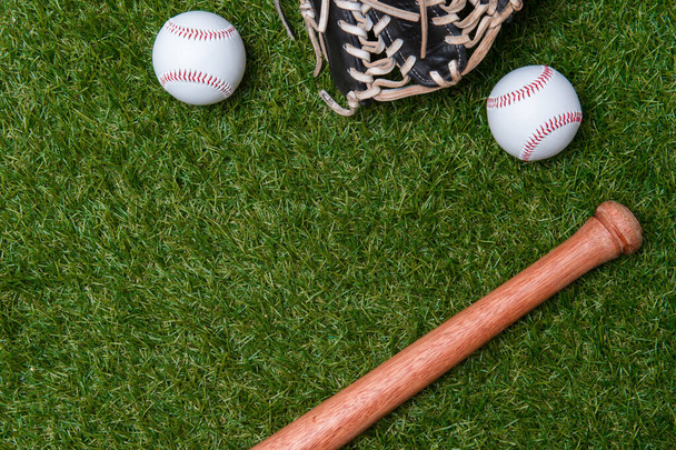 Pipistrello da baseball, guanto e palla sul campo di erba verde. Sport sfondo tema con spazio di copia per testo e pubblicità - Foto, immagini