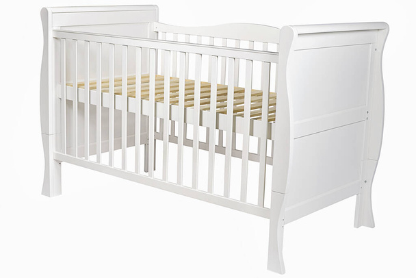 Λευκό ξύλινο κρεβάτι μωρού για ένα μωρό με πλευρές σε ένα απομονωμένο - Φωτογραφία, εικόνα