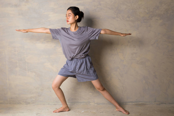 Портрет спортивной и спортивной молодой азиатки, занимающейся йогой, укрепляющей ноги, тренирующей выносливости, чтобы получить сильное здоровое тело - Фото, изображение