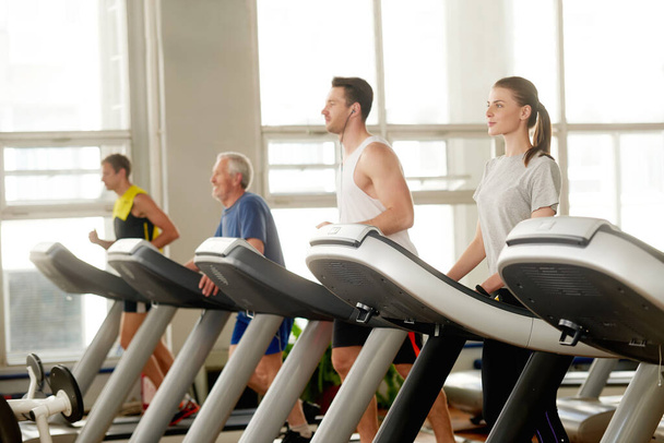 Young people on treadmill at fitness center. - Foto, Imagen
