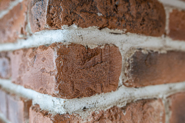 Odkryto tło kamiennej tekstury starożytnej kamiennej ściany. Kąt widzenia starej ściany z czerwonej cegły. - Zdjęcie, obraz