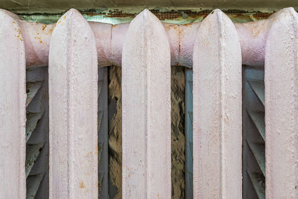 Staré litinové radiátory s odlupovací barvou pro ohřev vody na stěně vytápějí místnost - Fotografie, Obrázek