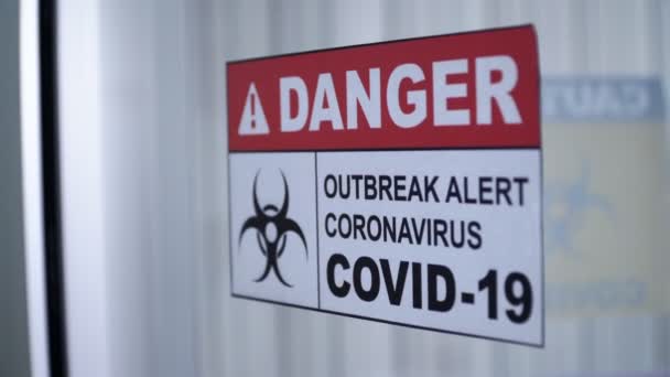 Warnschild für Coronavirus-Ausbruch mit Biohazard-Symbol an der Glastür. - Filmmaterial, Video