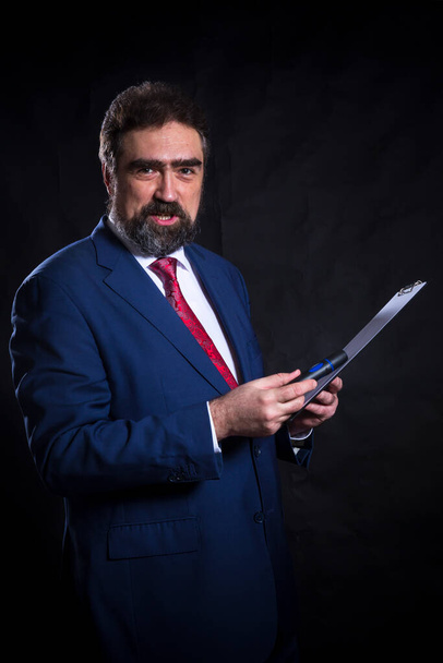 Hombre de negocios maduro vestido con traje azul con retrato de estudio de corbata roja. - Foto, Imagen