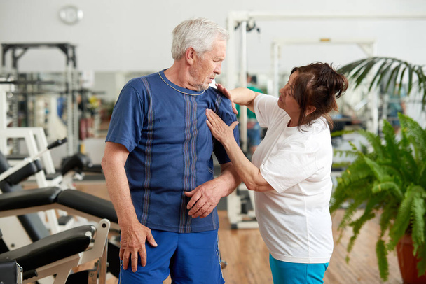 Senior man suffering from shoulder pain during training. - Foto, Imagem