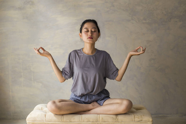 Asian woman do yoga practice meditating indoors, lotus position. No stress, mindfulness, inner balance concept - Photo, image