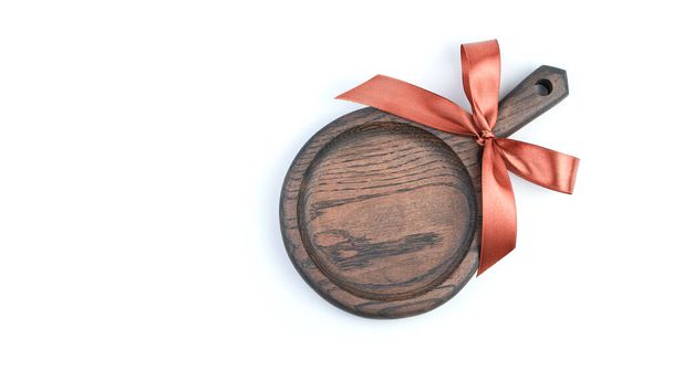 Beyaz arkaplanda hediye yayı olan kesme tahtası ile aşçılık arkaplanı - Fotoğraf, Görsel