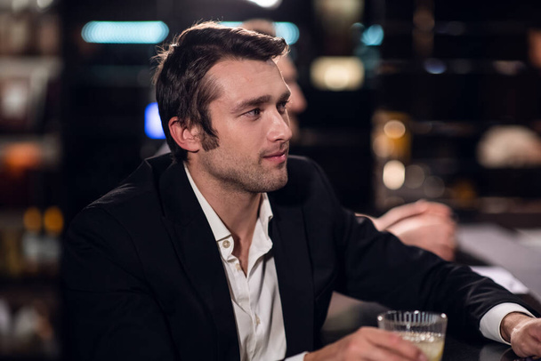 Bir barda elinde kokteyl, portre ve yakın çekim olan gömlek ve ceket giymiş yakışıklı bir adam. - Fotoğraf, Görsel