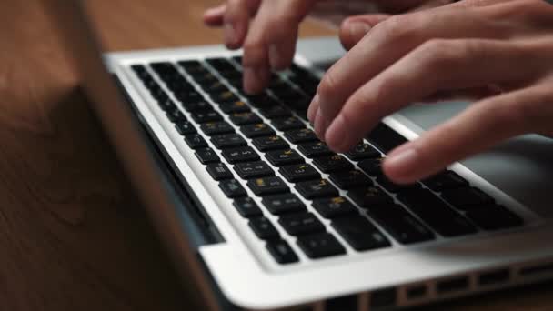 Close up man handen typen op laptop toetsenbord zitten aan de tafel thuis of op kantoor - Video