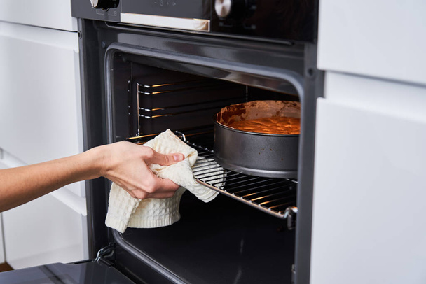 Hausfrau bereitet Kuchen in Küche zu. Hausgemachtes Kuchenbacken im Ofen - Foto, Bild