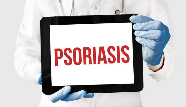Doctor in holds a tablet with text PSORIASIS - Photo, Image