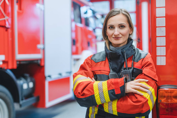 Жінка-винищувач стоїть перед пожежною машиною
 - Фото, зображення