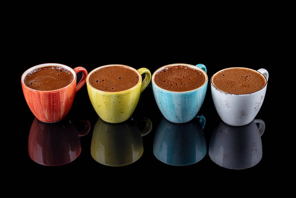 Café turco en coloridas tazas de porcelana aisladas sobre fondo negro. - Foto, Imagen