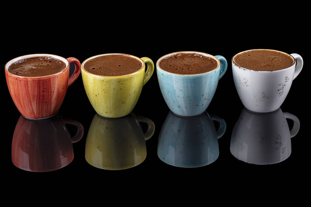 Turkse koffie in kleurrijke porseleinen bekers geïsoleerd op zwarte achtergrond. - Foto, afbeelding