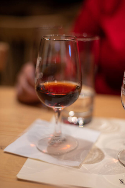 Profesionální ochutnávka různých opevněných zákusků rubínu, žlutohnědá portská vína ve sklenicích ve vinných sklepích v Portu, Portugalsko, zblízka - Fotografie, Obrázek
