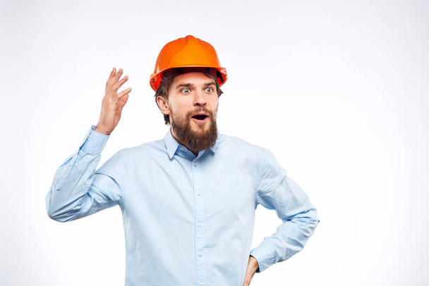 Ingenieur in oranje kleuring bouw professionele veiligheid industrie lichte achtergrond - Foto, afbeelding