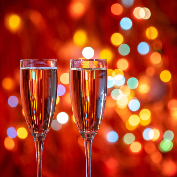 Copa de champán se cierran en Navidad y Año Nuevo vacaciones fondo bokeh. Dos vasos con burbujeante bebida espumosa sabrosa. ¡Feliz Año Nuevo! Celebración de las vacaciones de invierno, 4K, primer plano, macro - Foto, Imagen