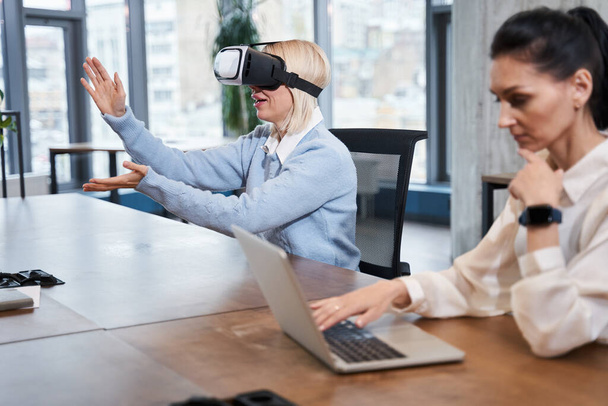 Woman wearing VR headset gesturing with hands - Valokuva, kuva