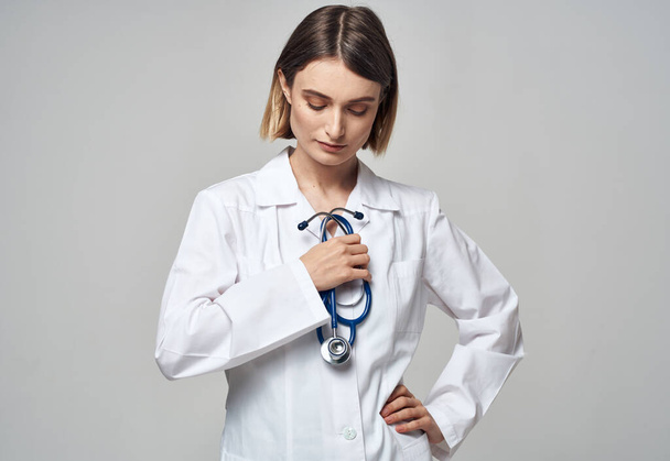 A professional doctor in a medical gown holds a stethoscope  - Photo, Image