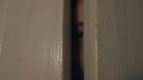 Ein Teenager schaut aus der Tür, um zu sehen, was draußen passiert. - Filmmaterial, Video